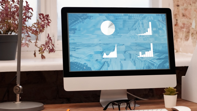 Attēls ar datora monitoru, uz tā redzami grafiki