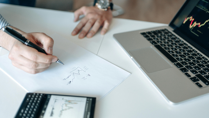 Attēls ar portatīvo datoru, cilvēks ar roku raksta uz lapas