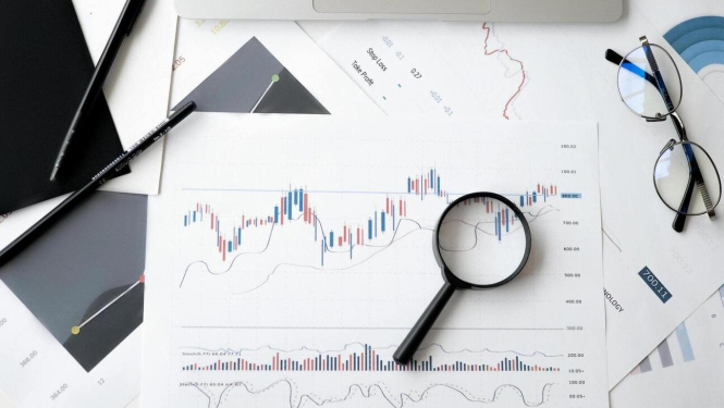 Attēls ar uz lapas uzzīmētu grafiku, uz lapas palielināmais stiks.